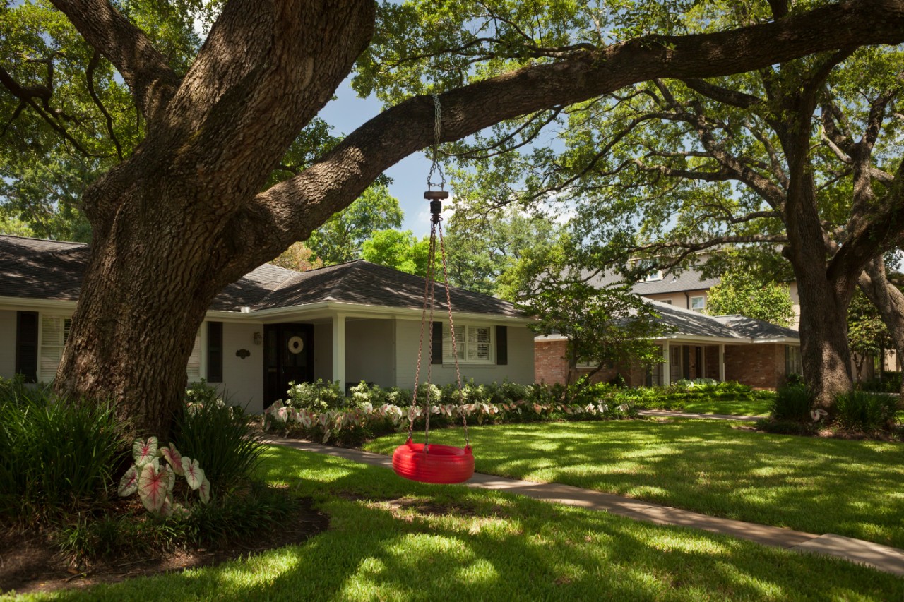 Home in Houston, Texas with red swing hanging from tree in front yard